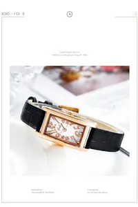 Detail einer Damen-Armbanduhr in Roségold mit schwarzem Lederarmband und weißem Zifferblatt