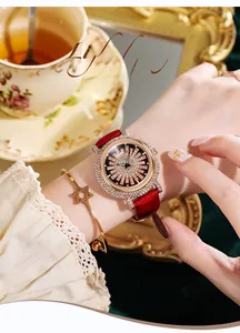 Gros plan sur une montre de luxe sertie de diamants avec bracelet en cuir rouge et jonc