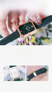 Detail showing the green leather strap and engraved stainless steel case back of the watch