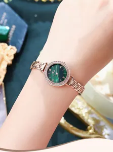 Detail of rose gold watch with emerald green dial and crystal bezel on female wrist