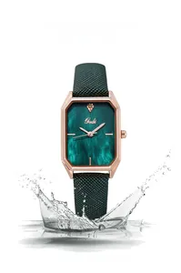 Detail of rose gold square watch with green dial showing 3ATM water resistance and splash