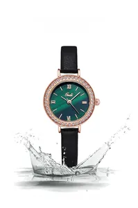 Détail de la montre en or rose avec lunette diamantée, cadran vert et éclaboussures d'eau