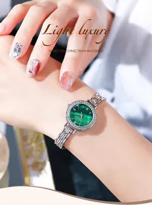 Detailed view of silver luxury watch featuring green malachite dial and rhinestone bezel