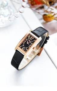 Makro-Detail der rechteckigen roségoldenen Uhr mit schwarzem Lederband und Blumendeko