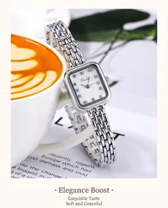 Détail d'une montre carrée argentée avec index en strass et bracelet à maillons en métal