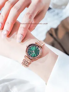 Primer plano detallado de un reloj con esfera verde, correa de metal en oro rosa y pedrería