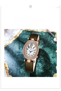 Détail d'une montre ovale en or rose avec lunette diamantée et bracelet cuir vert