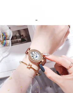 Montre ovale or rose avec lunette en strass, bracelet brun et bracelet étoile assorti