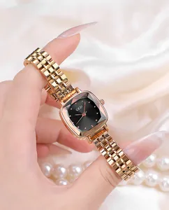 Detail of rose gold steel watch with faceted glass and black dial on silk background