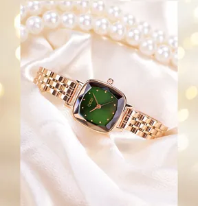 Detail of rose gold steel watch with green square dial on white silk with pearls