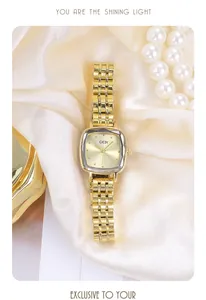 Close-up of elegant women's gold watch with faceted glass dial on champagne silk background
