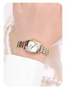 Close-up of golden steel watch with a geometric faceted glass face and mesh band