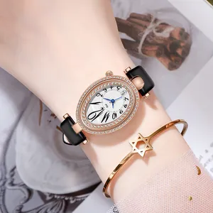 Montre ovale élégante en or rose avec strass et bracelet sur le poignet d'une femme