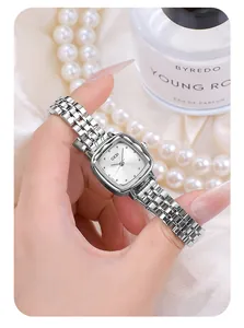 Elegant silver square quartz watch with metal mesh strap shown with luxury perfume
