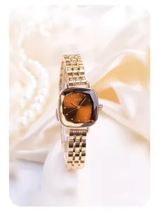 Detailed close-up of rose gold watch with faceted glass dial on white silk fabric