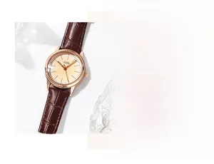 Detailed close-up of rose gold watch case with brown embossed leather strap