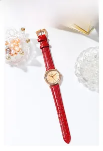 Detail of red crocodile leather strap and rose gold quartz watch for women