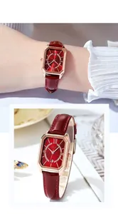 Details einer quadratischen roségoldenen Uhr mit burgunderfarbenem Lederarmband