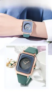 Close-up of rose gold square watch with dark blue dial and light green silicone strap