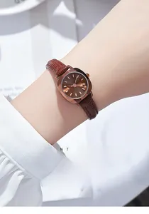 Gros plan d'une montre vintage GEDI avec boîtier en or rose et bracelet en cuir marron au poignet