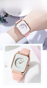 Detail of elegant pink silicone strap watch with rose gold square case and white round dial