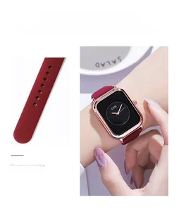 Detail of square quartz watch featuring burgundy silicone strap and rose gold metal case