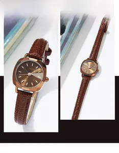 Détail macro du boîtier carré doré vintage avec bracelet en cuir brun et cadran soleil