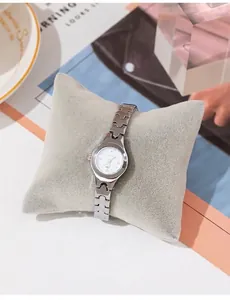 Detailed macro of a silver quartz watch featuring a rhinestone dial and H-link metal strap