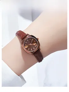 Détail d'une montre carrée pour femme en or rose avec bracelet en cuir marron sur le poignet