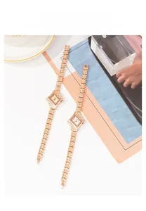 Detail of luxury rhinestone-encrusted diamond-shaped watch in gold and rose gold
