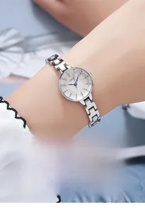 Close-up of a delicate silver steel strap women's watch with a white minimalist dial