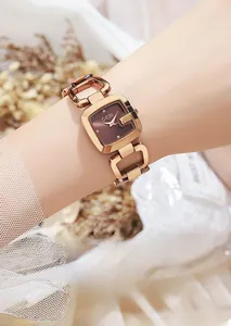 Détail de la montre bracelet en or rose avec cadran carré brun sur le poignet