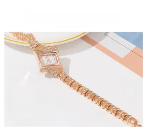 Detail of rose gold rhombus watch with sparkling crystals and segmented metal bracelet