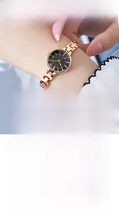 Detail of rose gold stainless steel watch with black dial on female wrist and white base