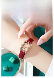 Detailansicht der rechteckigen Uhr in Roségold mit rotem Lederarmband und Zifferblatt