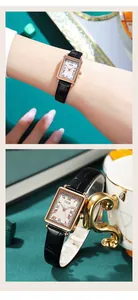 Makroaufnahme der rechteckigen roségoldenen Uhr mit römischen Ziffern und Lederarmband