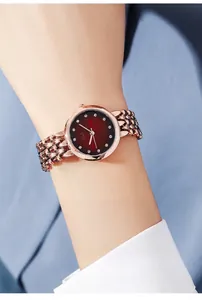 Dettaglio orologio da donna in oro rosa con quadrante rosso rubino e indici in cristallo