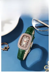 Detail of luxury GEDI watch featuring rose gold oval case with diamonds and green leather strap