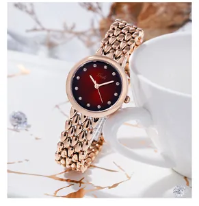 Dettaglio dell'orologio Gedi oro rosa con quadrante rosso sfumato su marmo