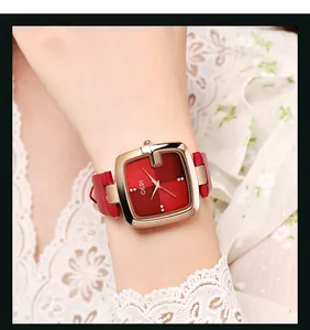 Nahaufnahme einer luxuriösen quadratischen Uhr mit rotem Zifferblatt und Roségold