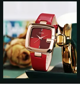 Nahaufnahme der quadratischen roségoldenen Uhr mit rotem Lederarmband und Strasssteinen