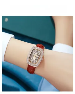 Close-up of luxury women's watch with crystal-encrusted oval bezel and red leather strap