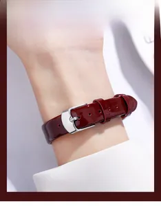 Detail of red patent leather watch strap with glossy finish and silver buckle for women