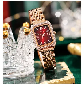 Detail of rose gold rectangular watch with red dial and crystal bezel on crown base