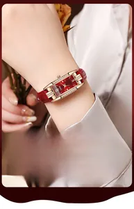 Gros plan d'une montre à quartz rectangulaire en or rose avec bracelet en cuir rouge