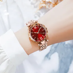 Montre en maille or rose élégante avec cadran rouge foncé sur le poignet d'un mannequin