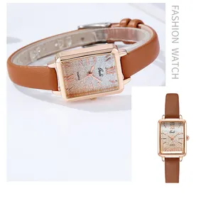Close-up of square rose gold quartz watch with gradient dial and brown leather strap