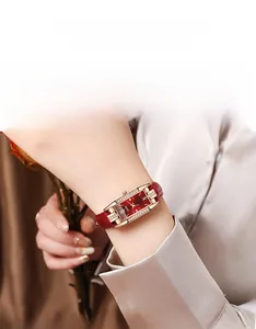 Gros plan d'une montre carrée pour femme avec cadran rouge et boîtier diamanté