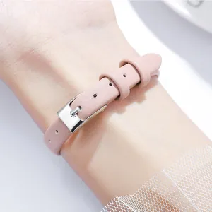 Women's quartz watch with pink leather strap and silver buckle on a wrist