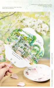 Détail d'un éventail décoratif avec motif de jardin et poignée en plastique transparent